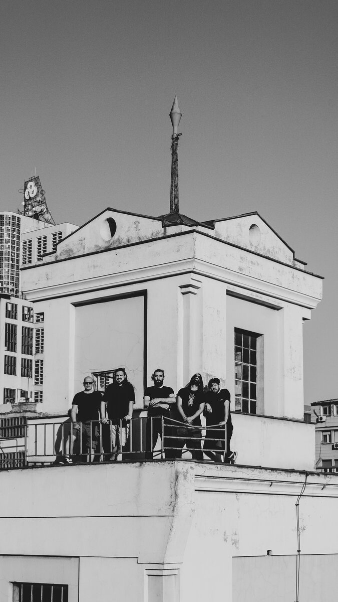 Group of five people on a rooftop terrace of a classical building