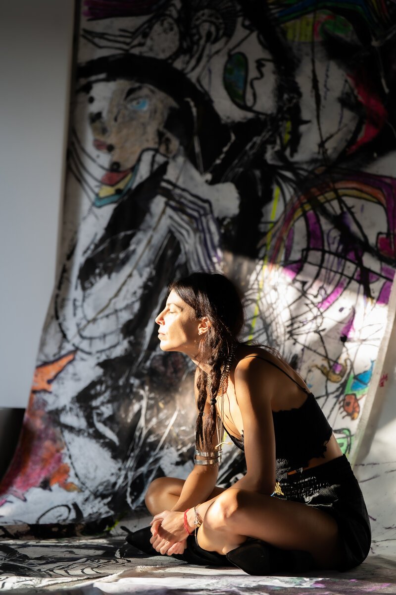 woman with braid, profile in sunlight, seated before large expressive painting